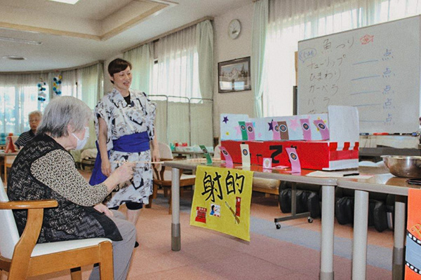 納涼祭で射的を楽しむ高齢者