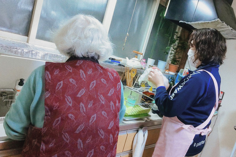 キッチンで料理をしている利用者とスタッフ