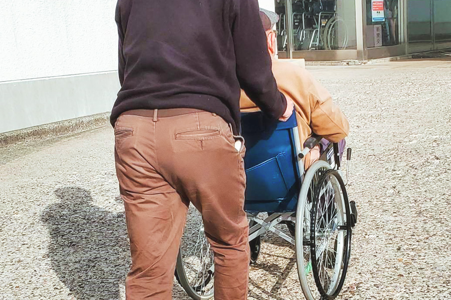 ヘルパーステーションおきだてのスタッフに車いすを押して貰っている利用者