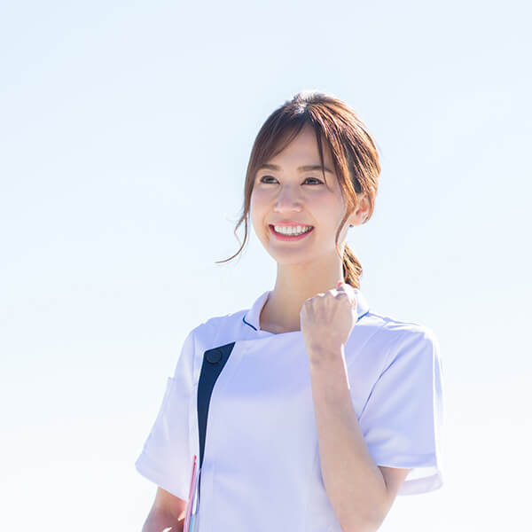 笑顔でガッツポーズをしている先輩社員の女性イメージ