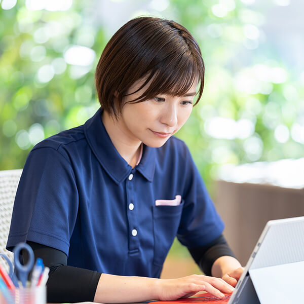 デスクでノートパソコンに入力している先輩社員の女性イメージ