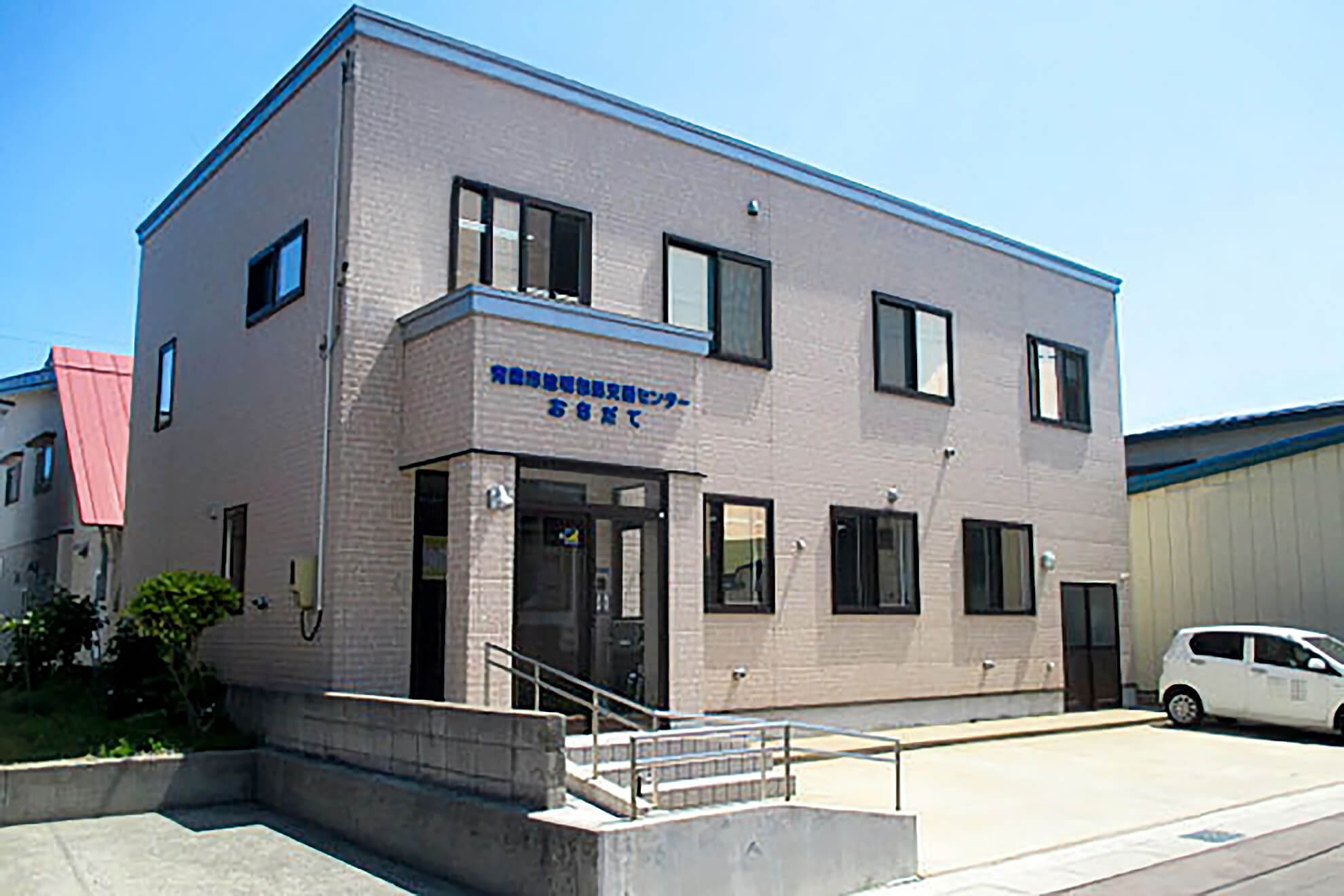 車いすの高齢者を送迎しているスタッフと自動車